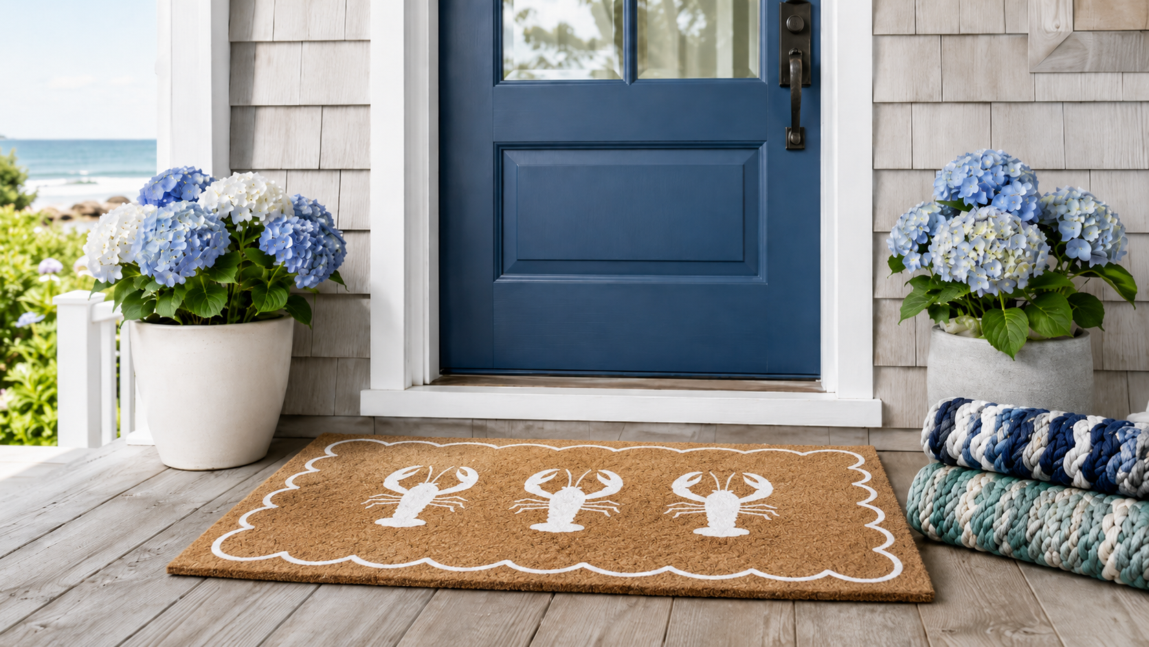 Scalloped lobster coir doormat at a blue Nantucket front door with hydrangeas and stacked lobster rope mats